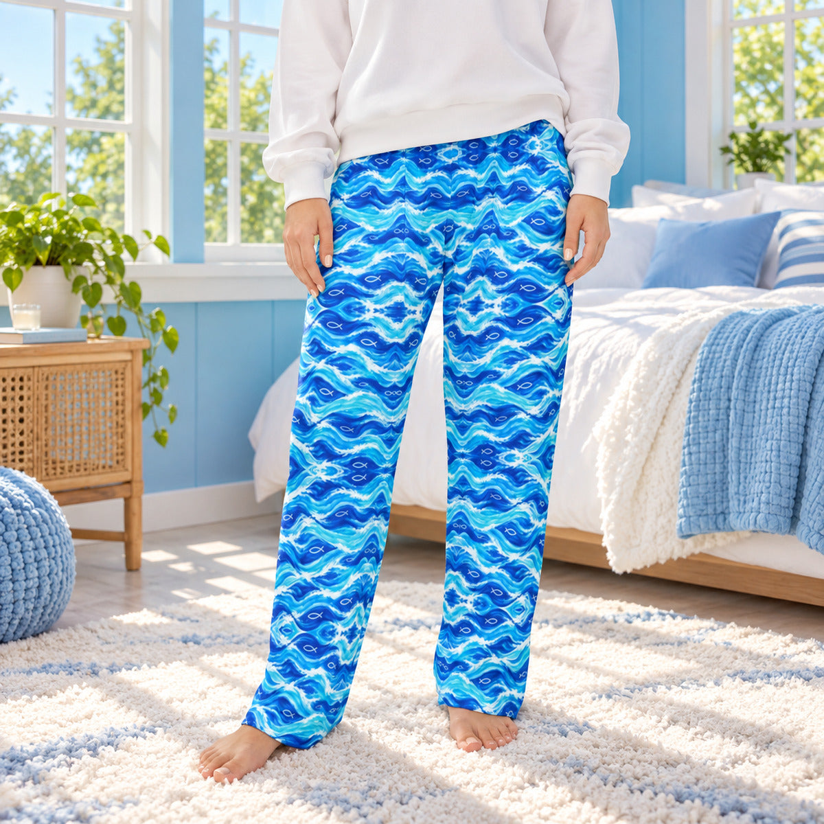 Lifestyle photo: Living Water Waves faith-based all-over-print pajama pants in a cozy bedroom setting.