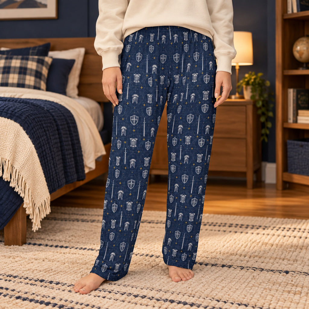 Lifestyle photo: Full Armor Blueprint faith-based all-over-print pajama pants in a cozy bedroom setting.